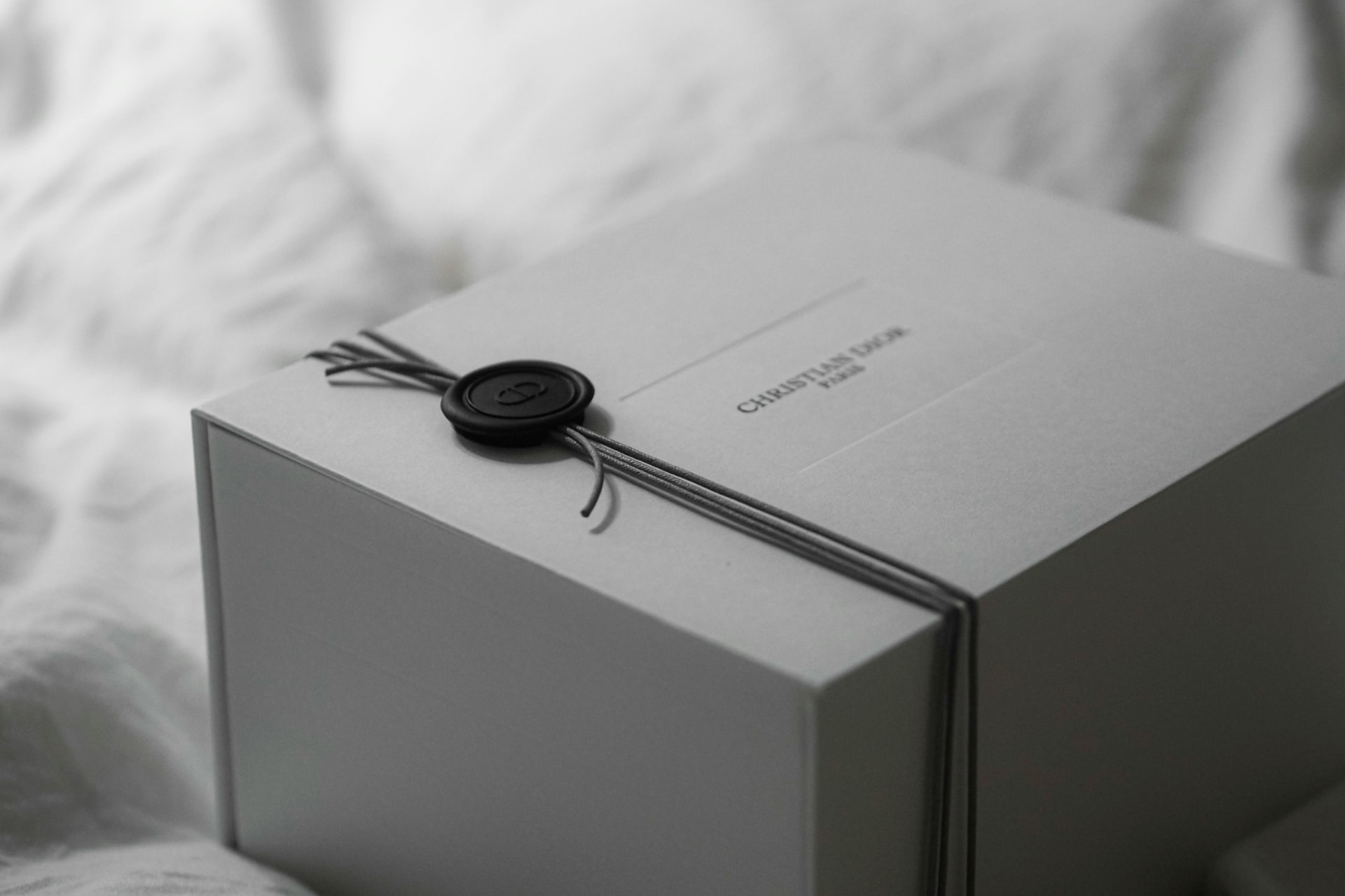 Cofanetto regalo profumo elegante grigio chiaro chiuso con sigillo in ceralacca nero e cordoncino