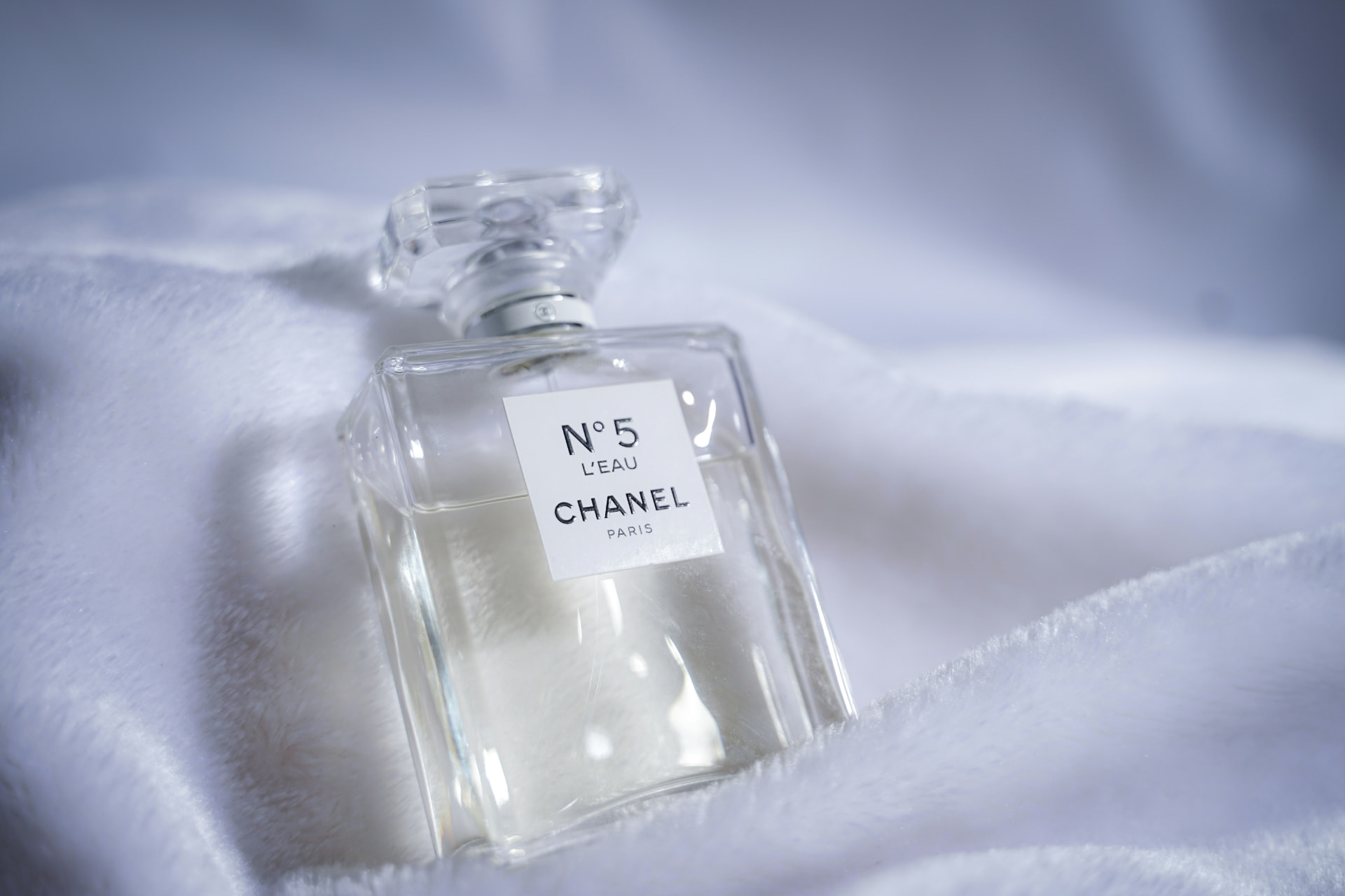 Flacone Chanel N°5 L'Eau adagiato su un tessuto bianco morbido