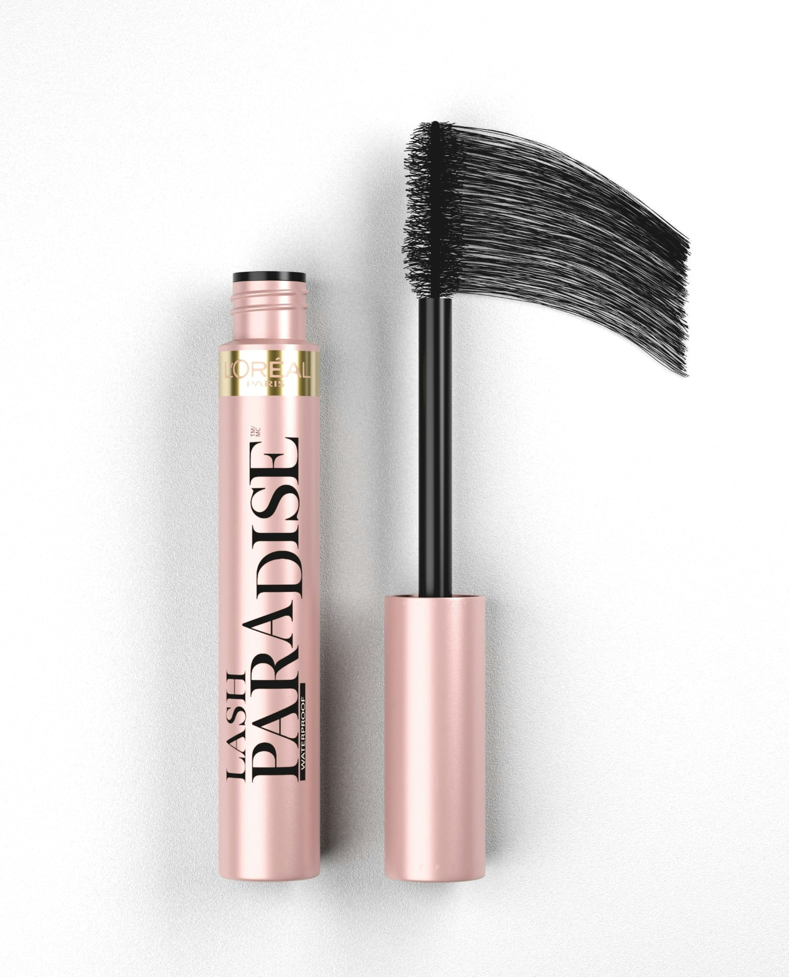 Mascara rosa con scovolino nero e swatch di texture su fondo bianco