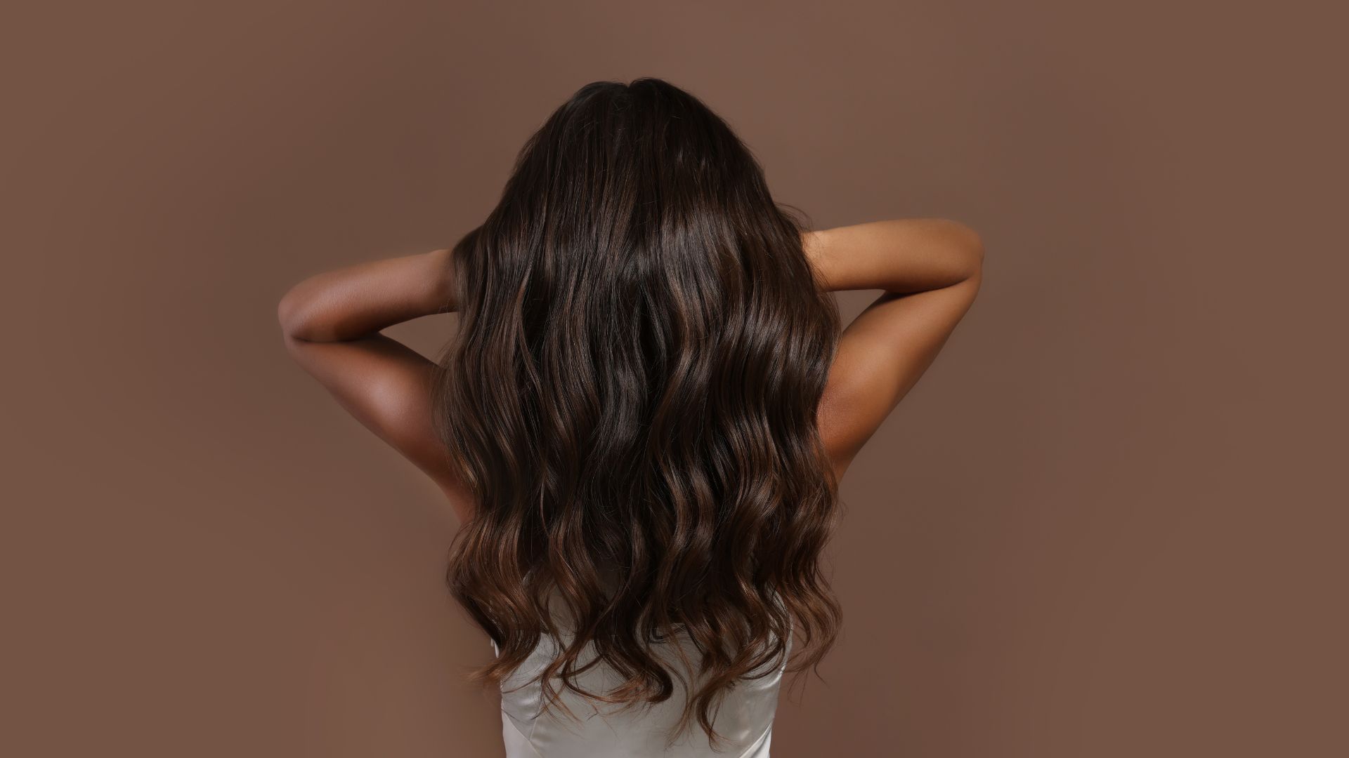 Capelli lunghi castani ondulati e curati visti da dietro