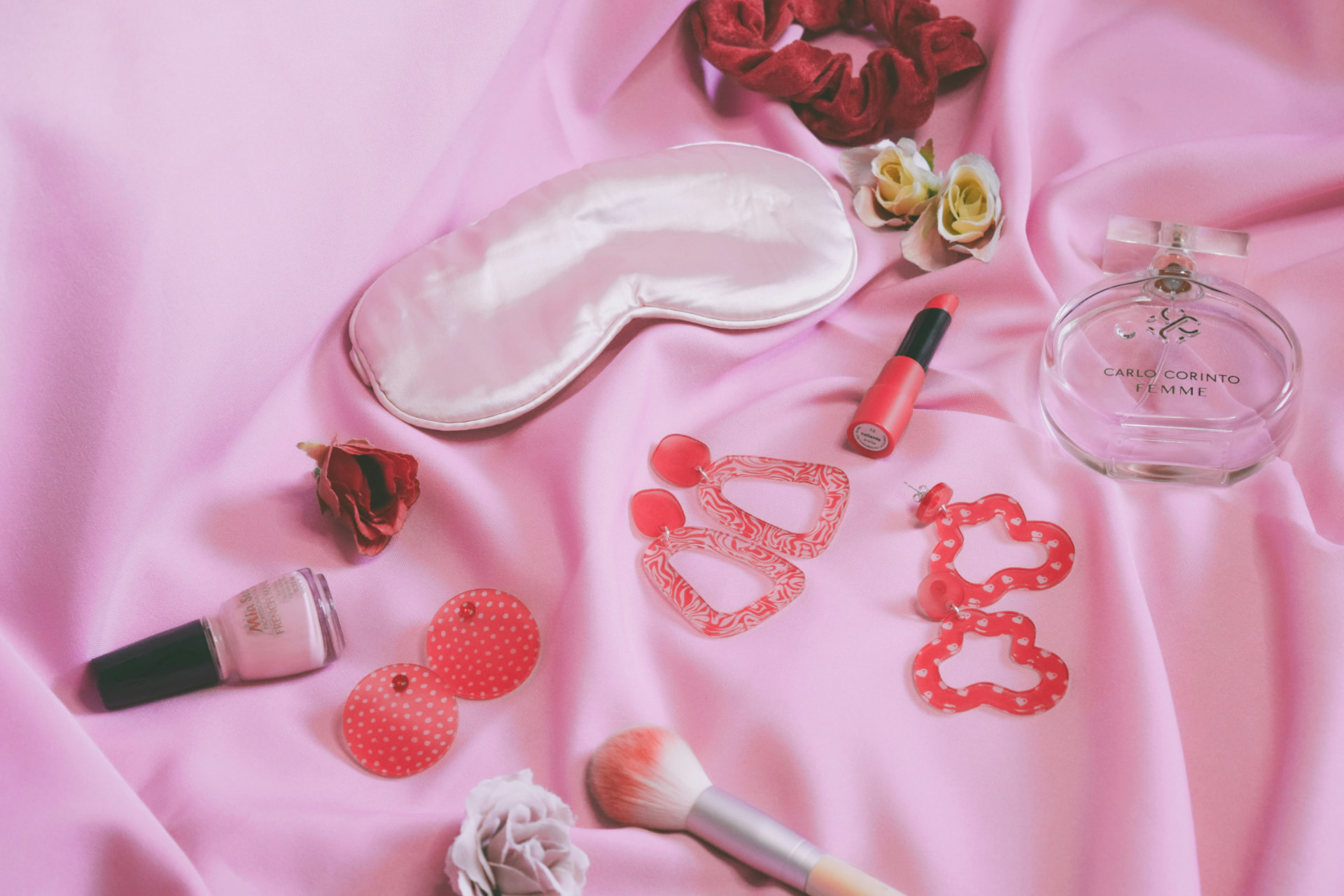 Rossetto, smalto, pennello e profumo su raso rosa: idee per un cofanetto trucco di San Valentino