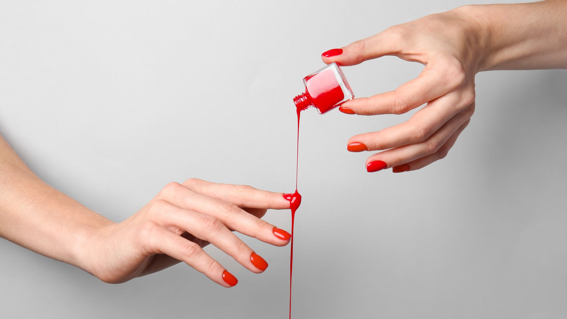Smalto rosso che cola sulle unghie