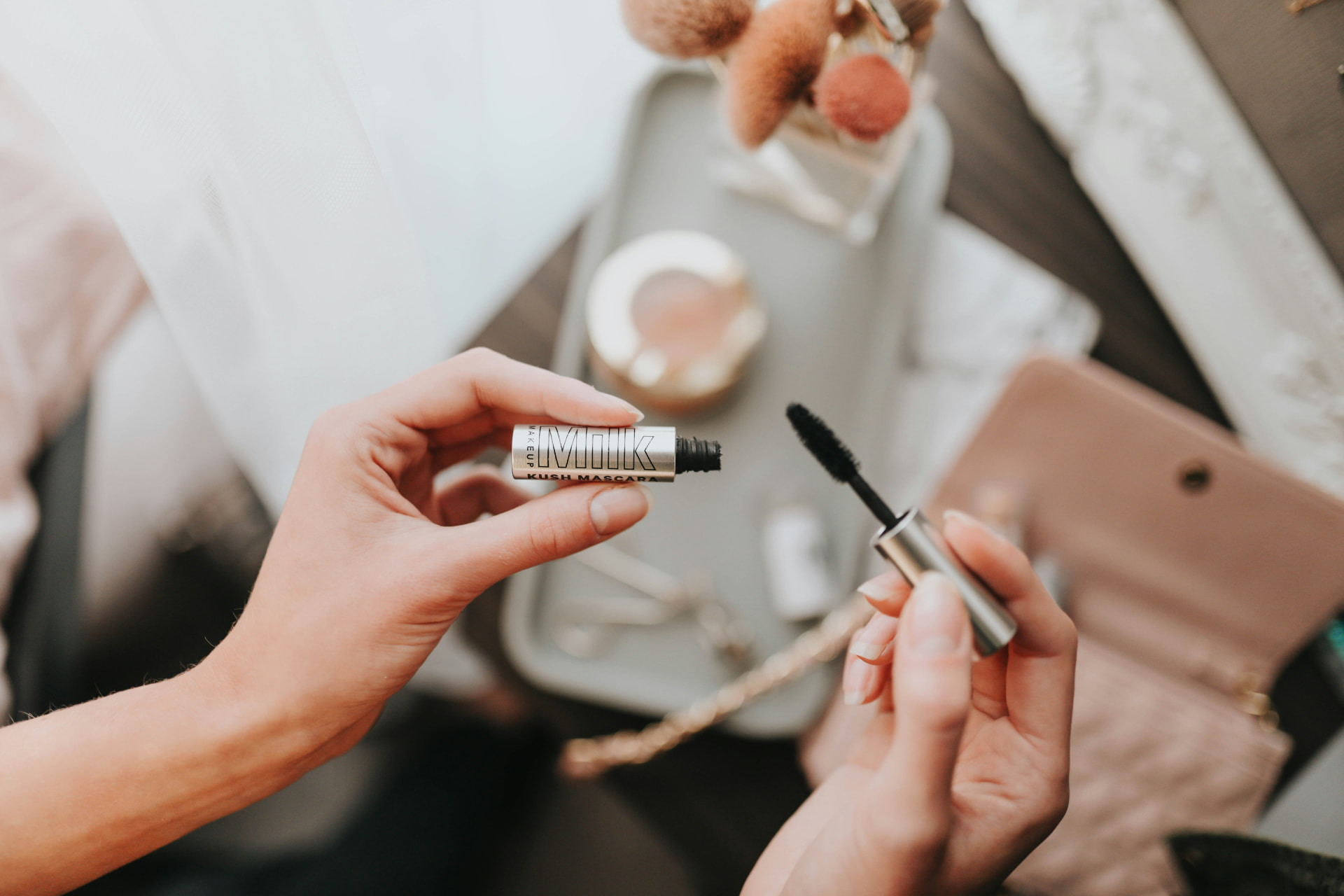 Mascara nero aperto tra accessori da trucco