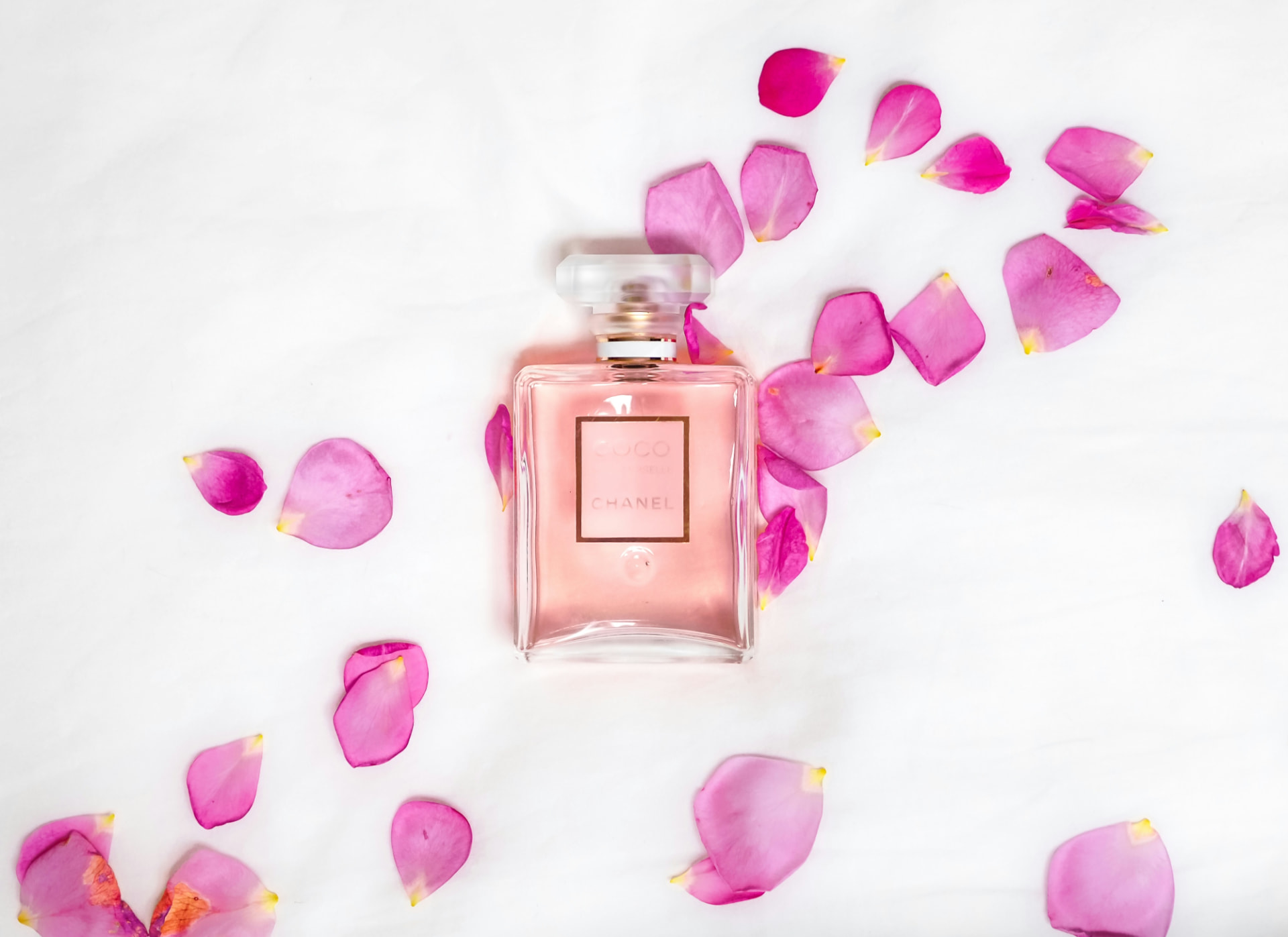 Flacone di profumo rosa con petali di rosa — nuovi profumi donna 2026
