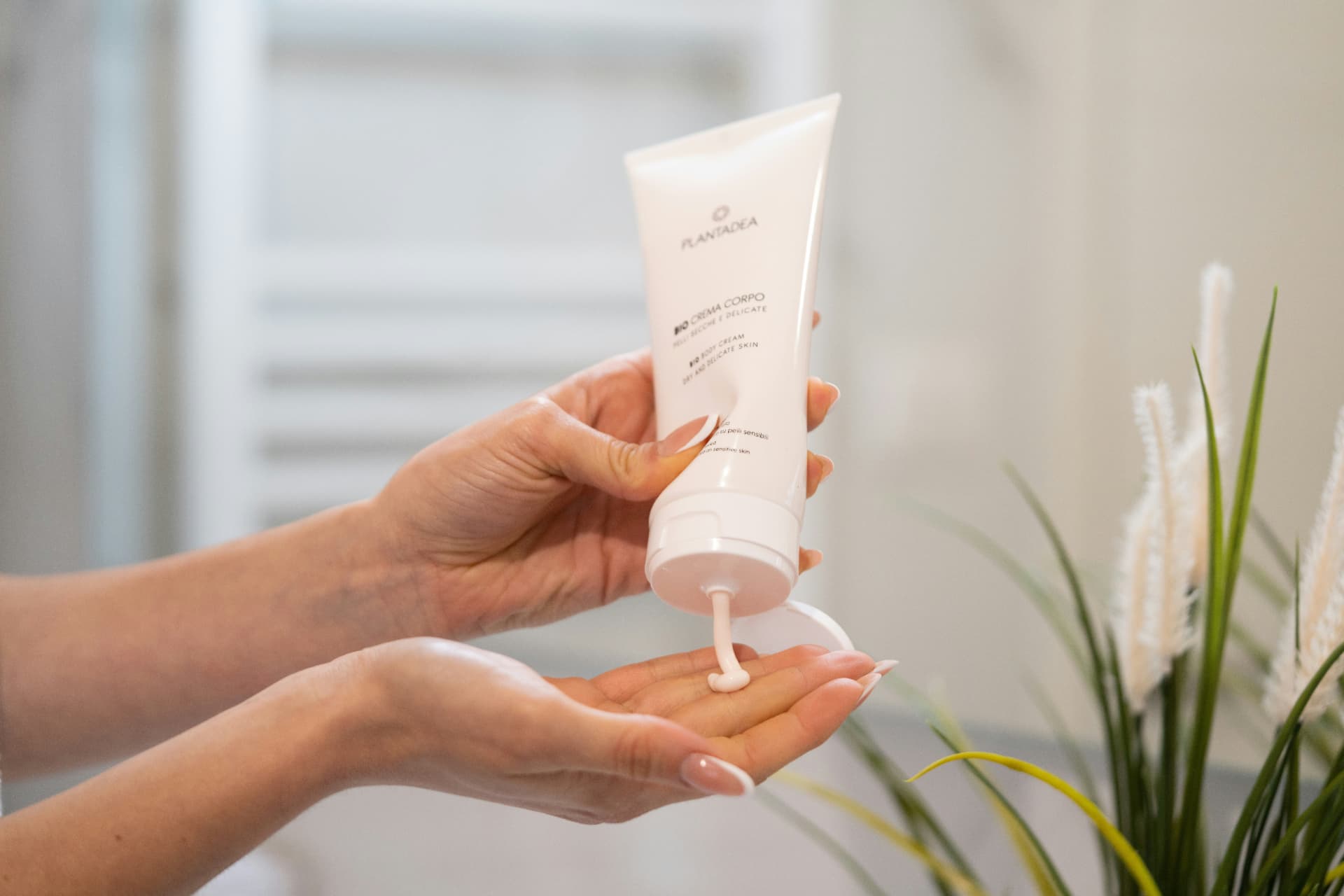 Crema corpo idratante erogata dal tubetto sul palmo