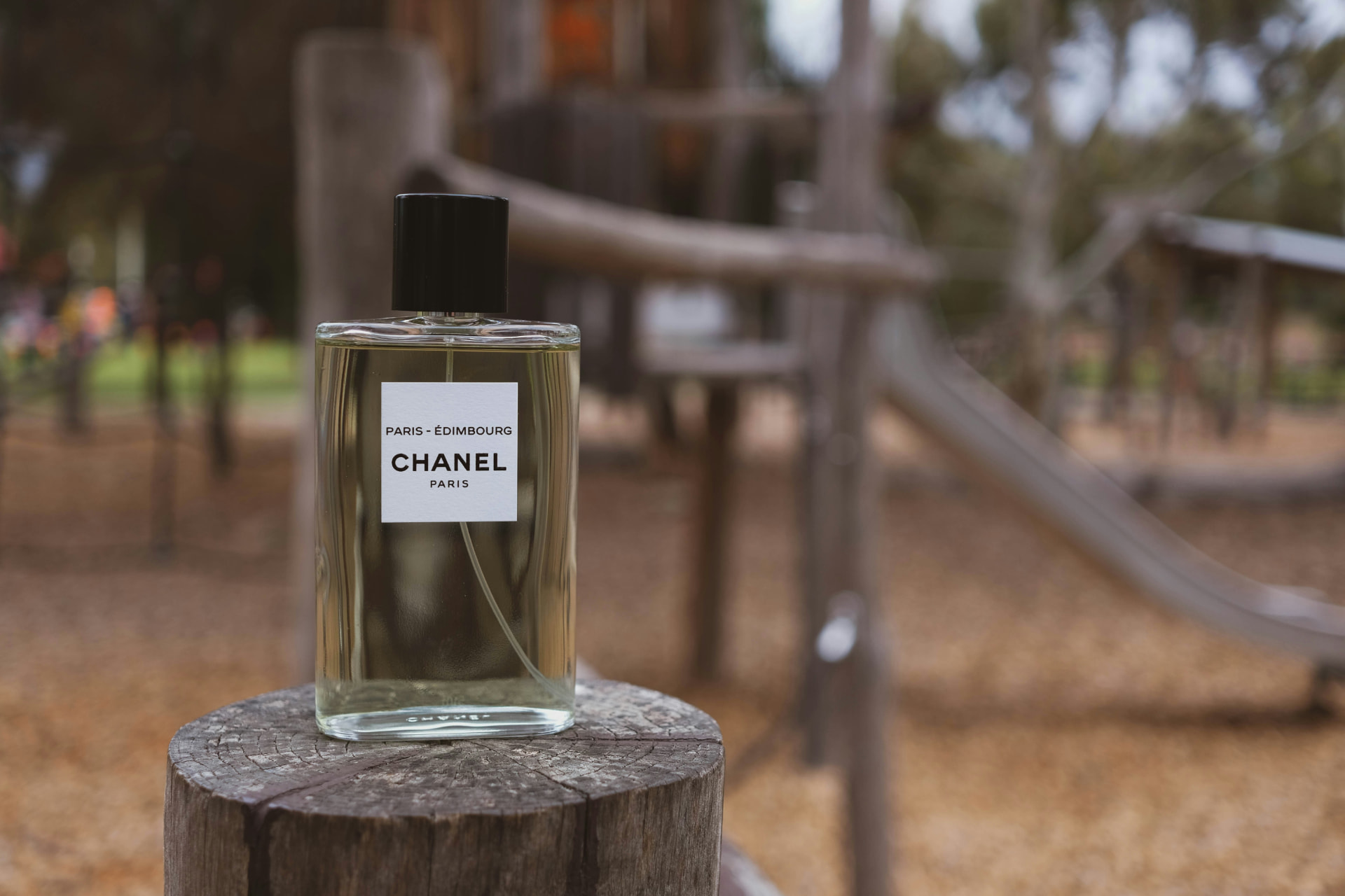 Flacone di profumo Chanel su un tronco di legno: le note di cedro