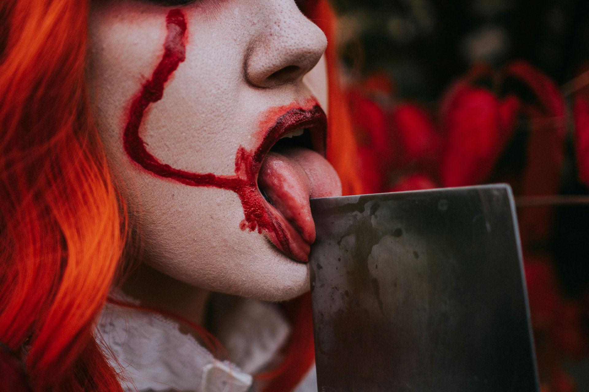 Dettaglio di trucco Halloween da clown horror con linee rosse e sangue finto