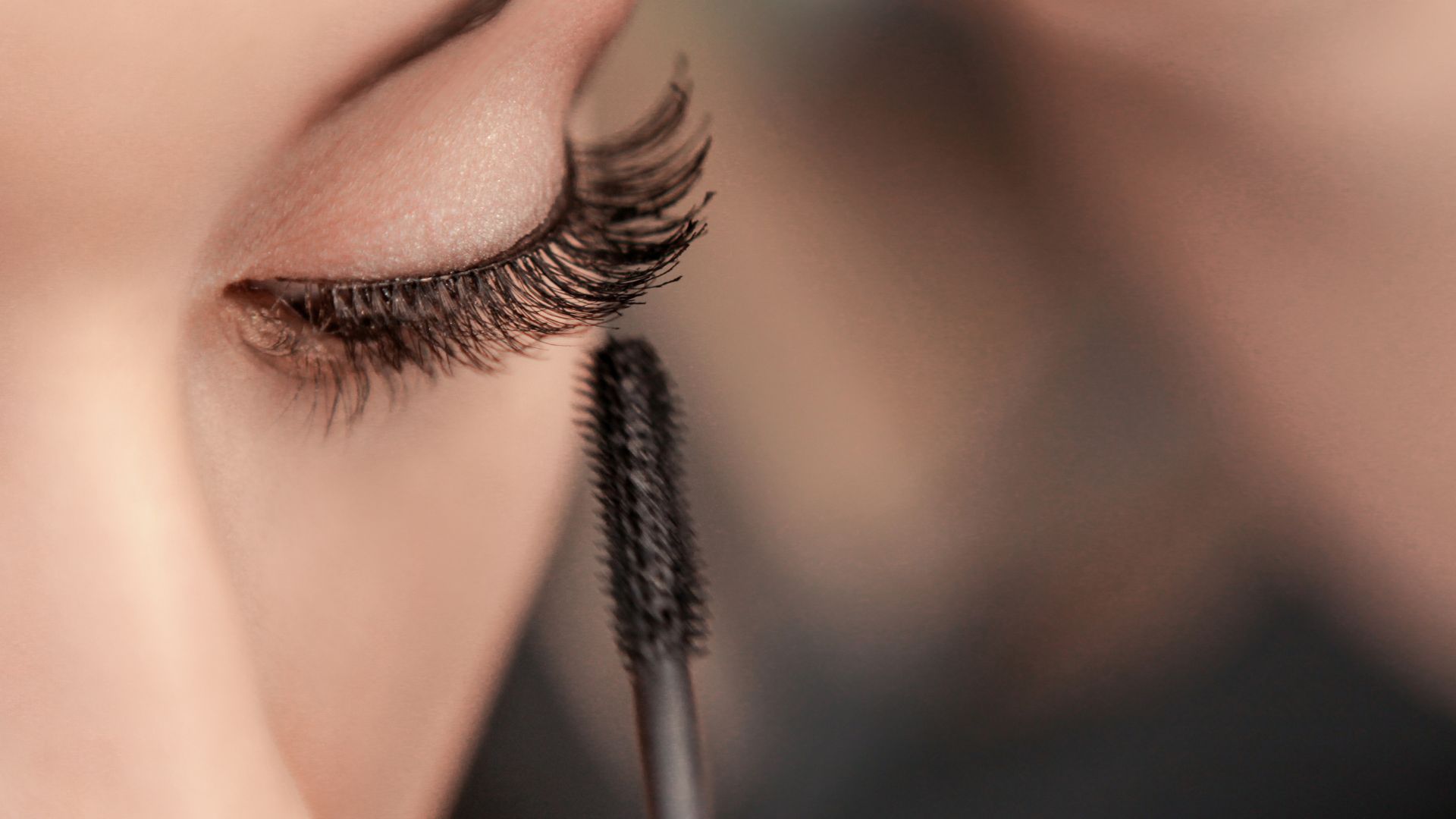 Piegaciglia accanto a un mascara su un piano da trucco