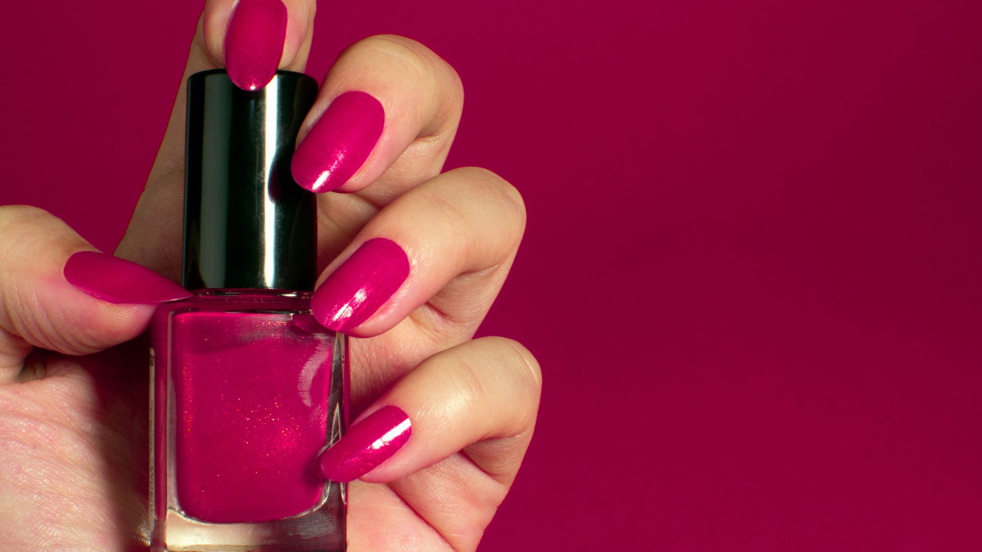 Smalto fucsia brillante su unghie a mandorla