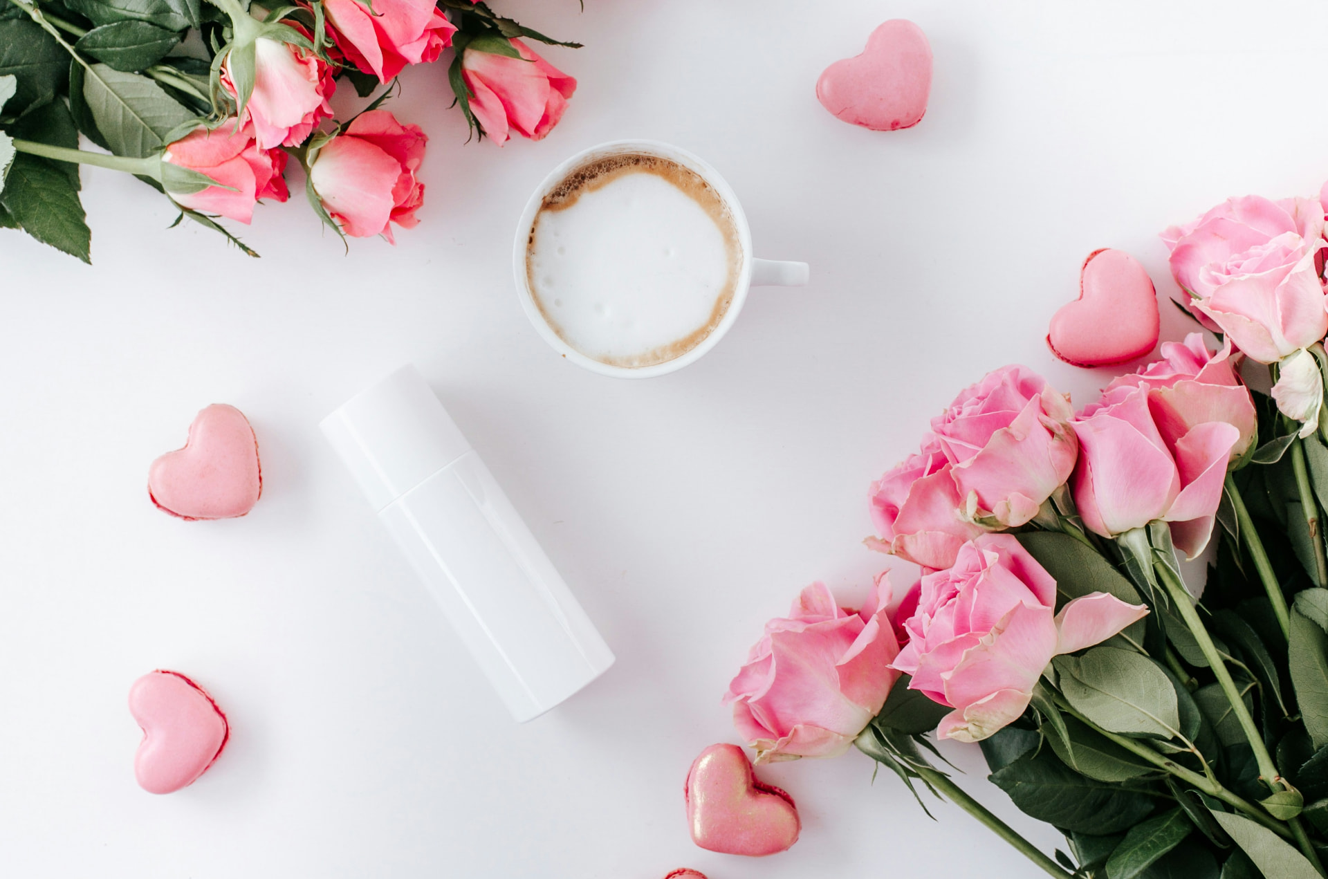 Flacone beauty bianco tra rose rosa e macarons a cuore, classifica dei migliori cofanetti San Valentino