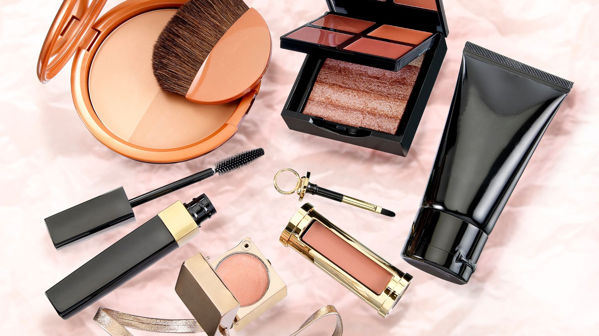 Cosmetici assortiti: cipria, palette, mascara e pennello su fondo rosa