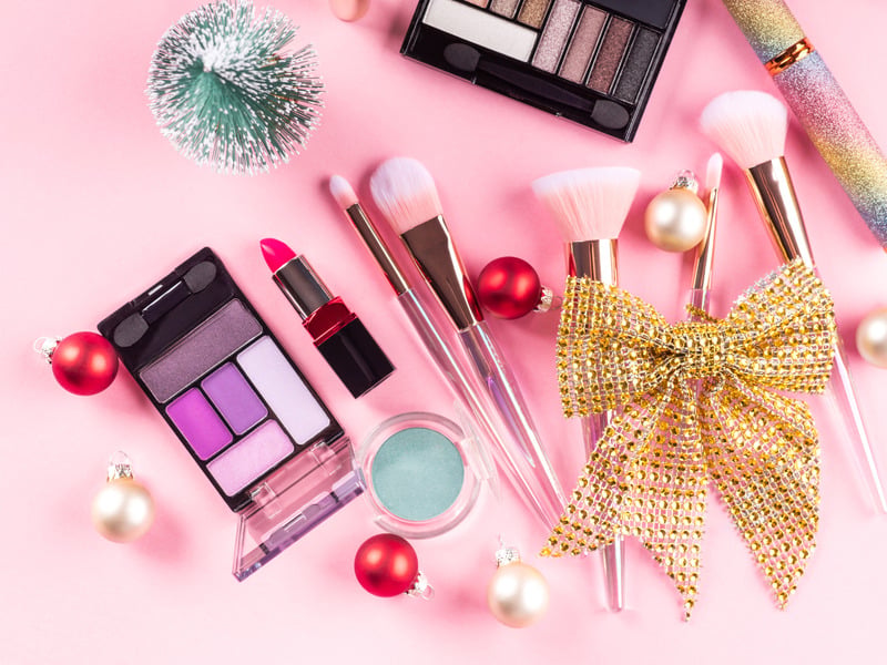 Palette e pennelli trucco su fondo rosa natalizio