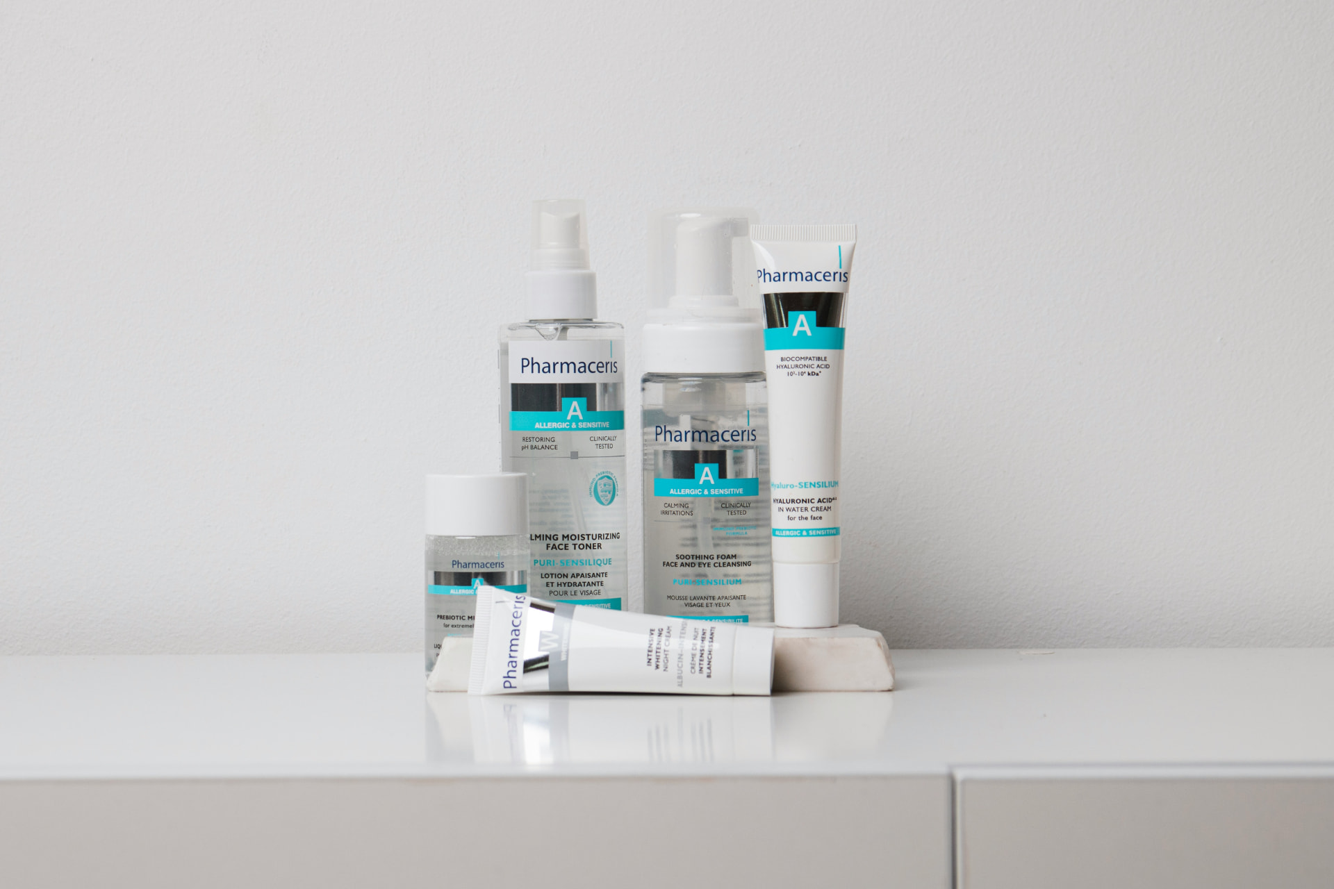 Detergente viso in schiuma, tonico e crema per pelli sensibili su mensola bianca