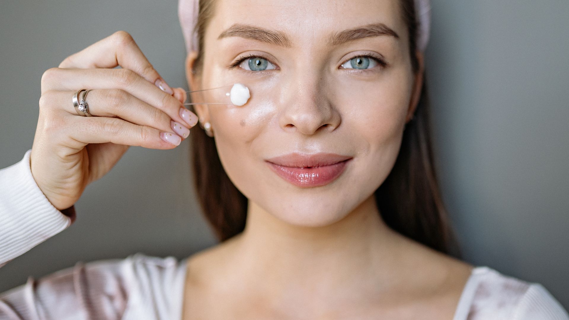 Donna che applica un prodotto skincare sul viso