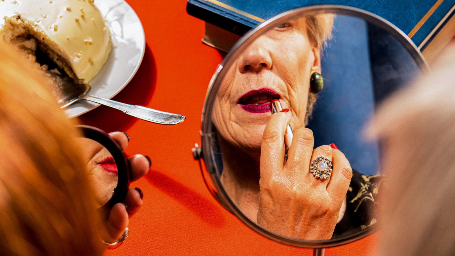 Donna matura che applica il rossetto allo specchio