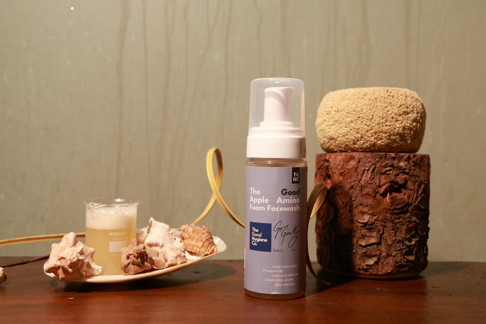 Flacone di detergente viso in schiuma tra elementi botanici naturali