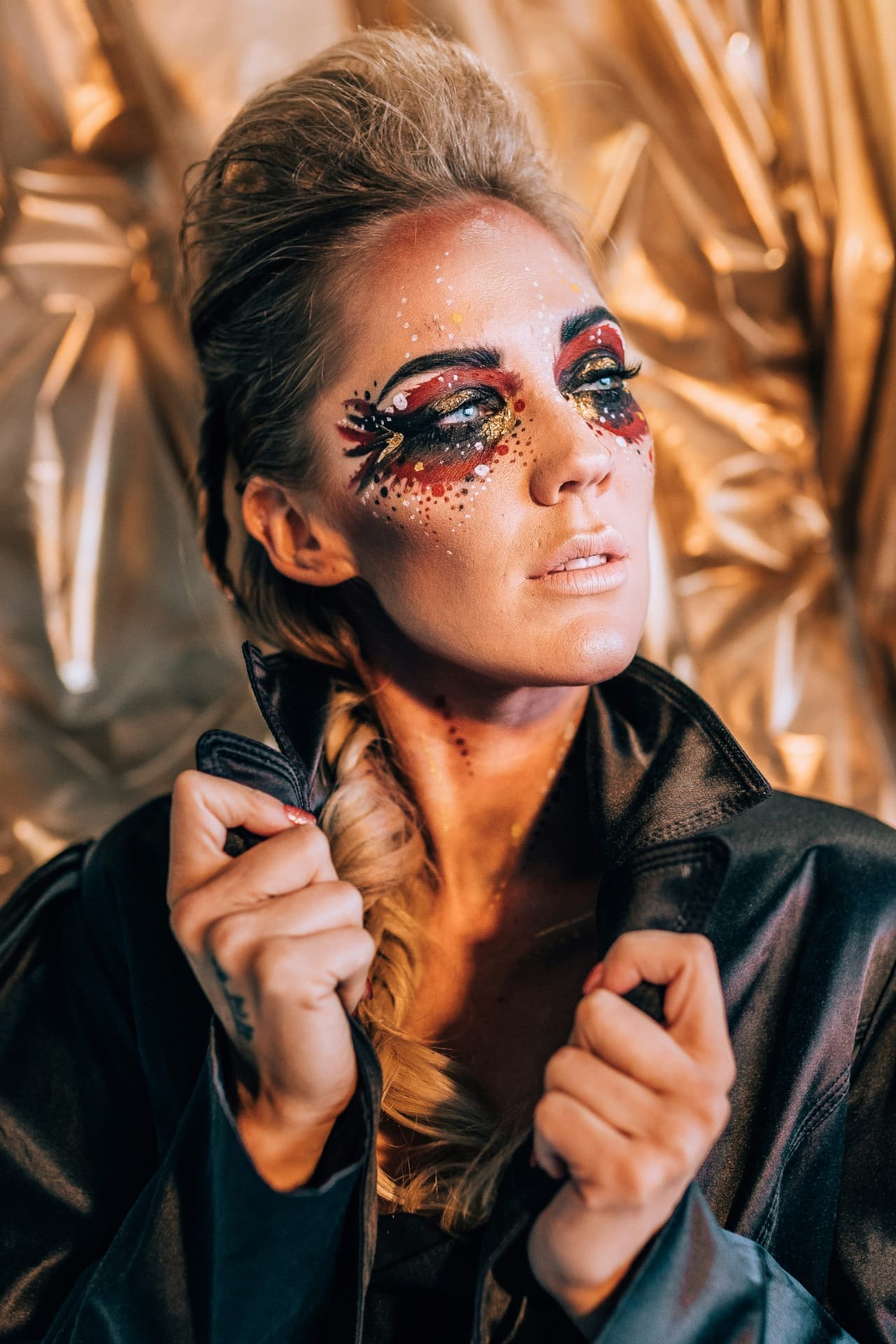 Contouring teatrale con sfumature rosse, oro e glitter su occhi e zigomi