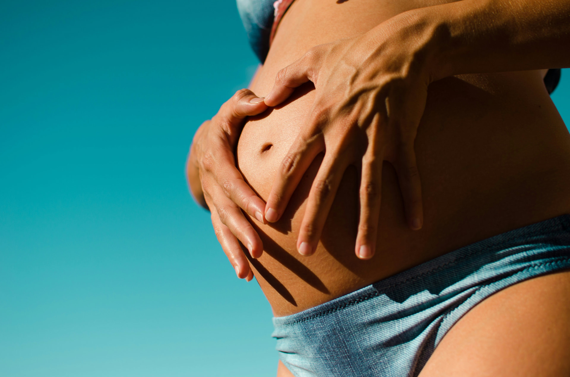 Donna in gravidanza che applica una crema sulla pancia