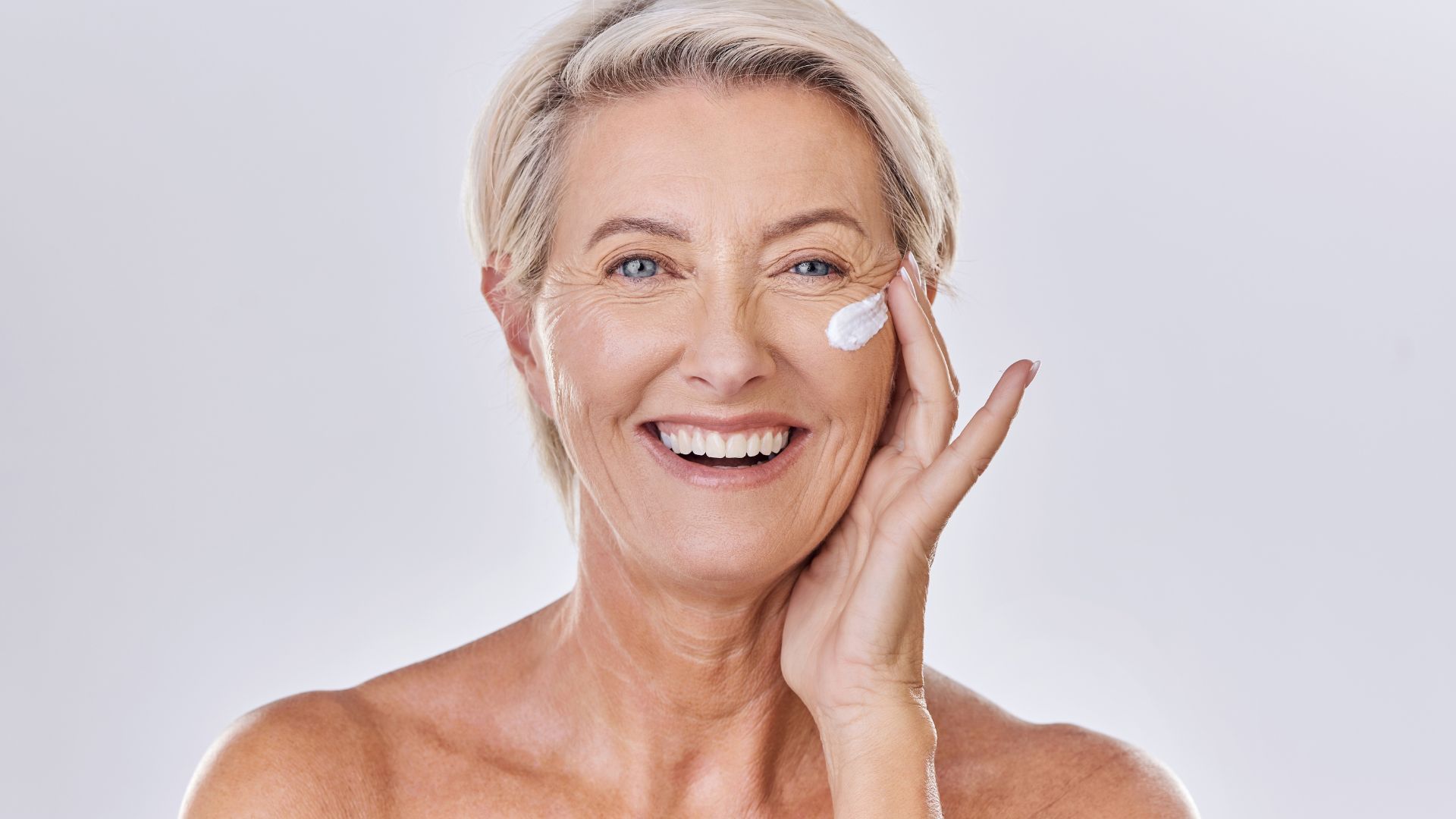 Donna matura con crema idratante prima del trucco