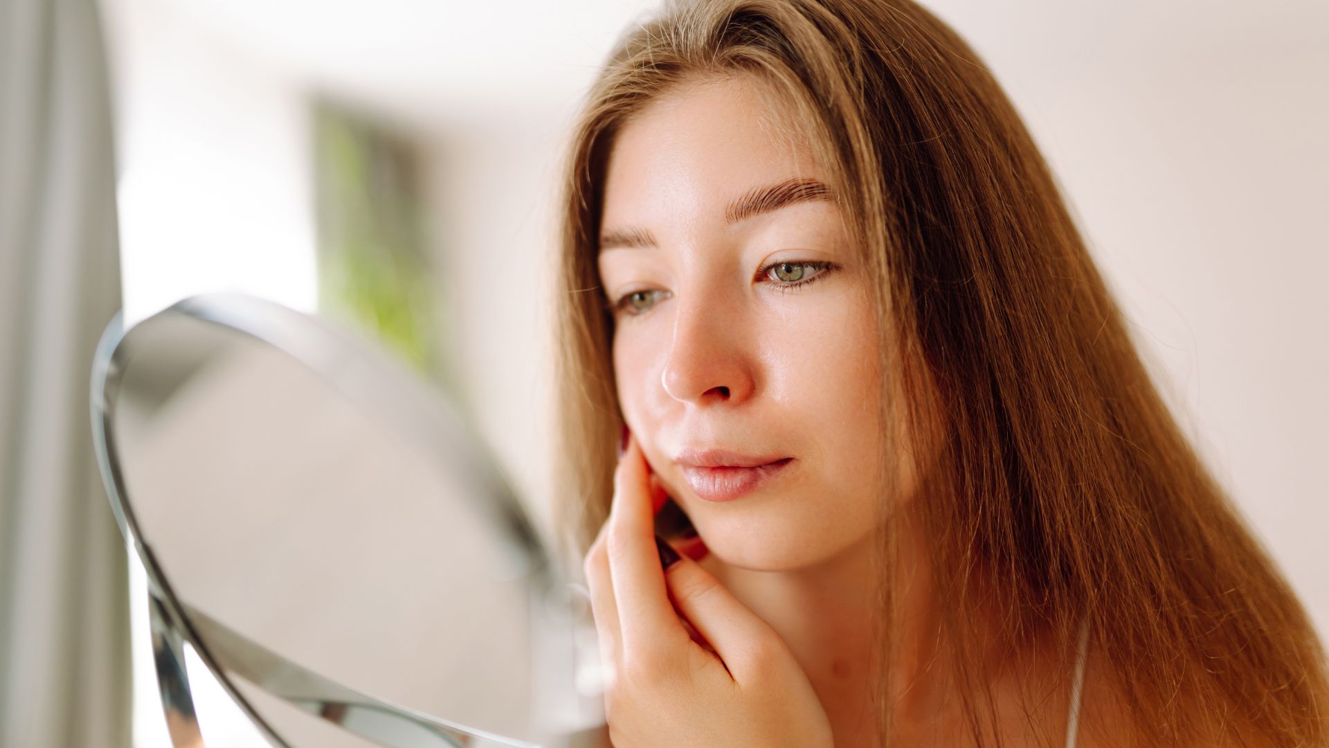 Giovane donna che si prende cura della pelle con imperfezioni