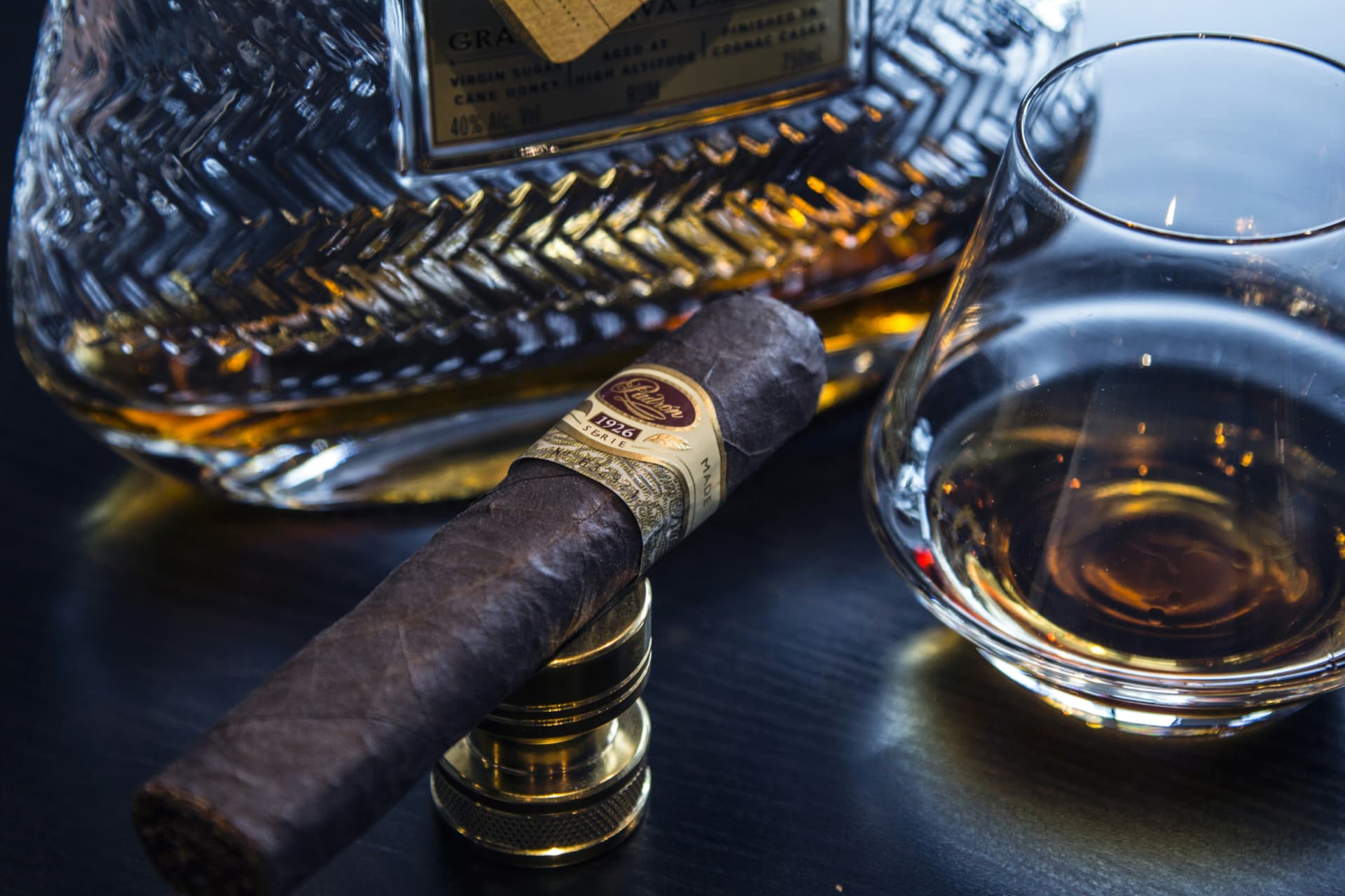 Sigaro e caraffa con distillato ambrato