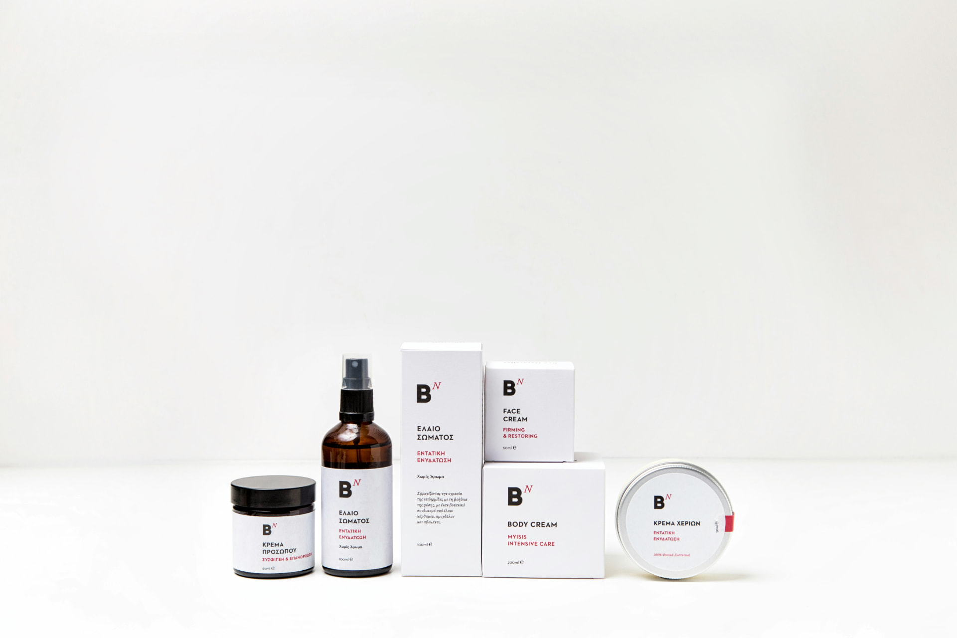 Linea di creme viso e corpo in vasetti e scatole bianche su fondo chiaro