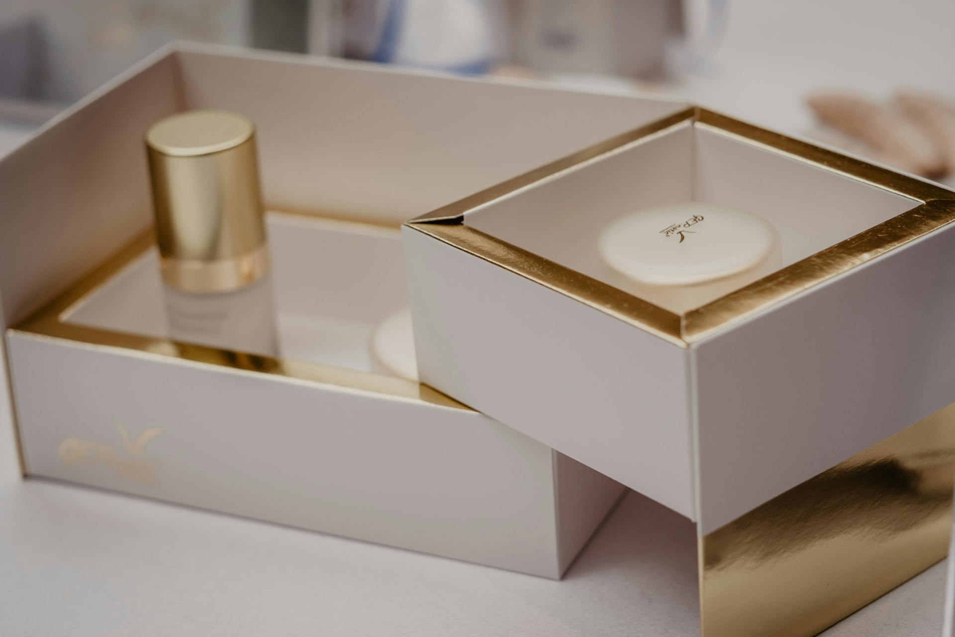 Cofanetto skincare di lusso bianco e oro aperto con flacone di siero e crema viso