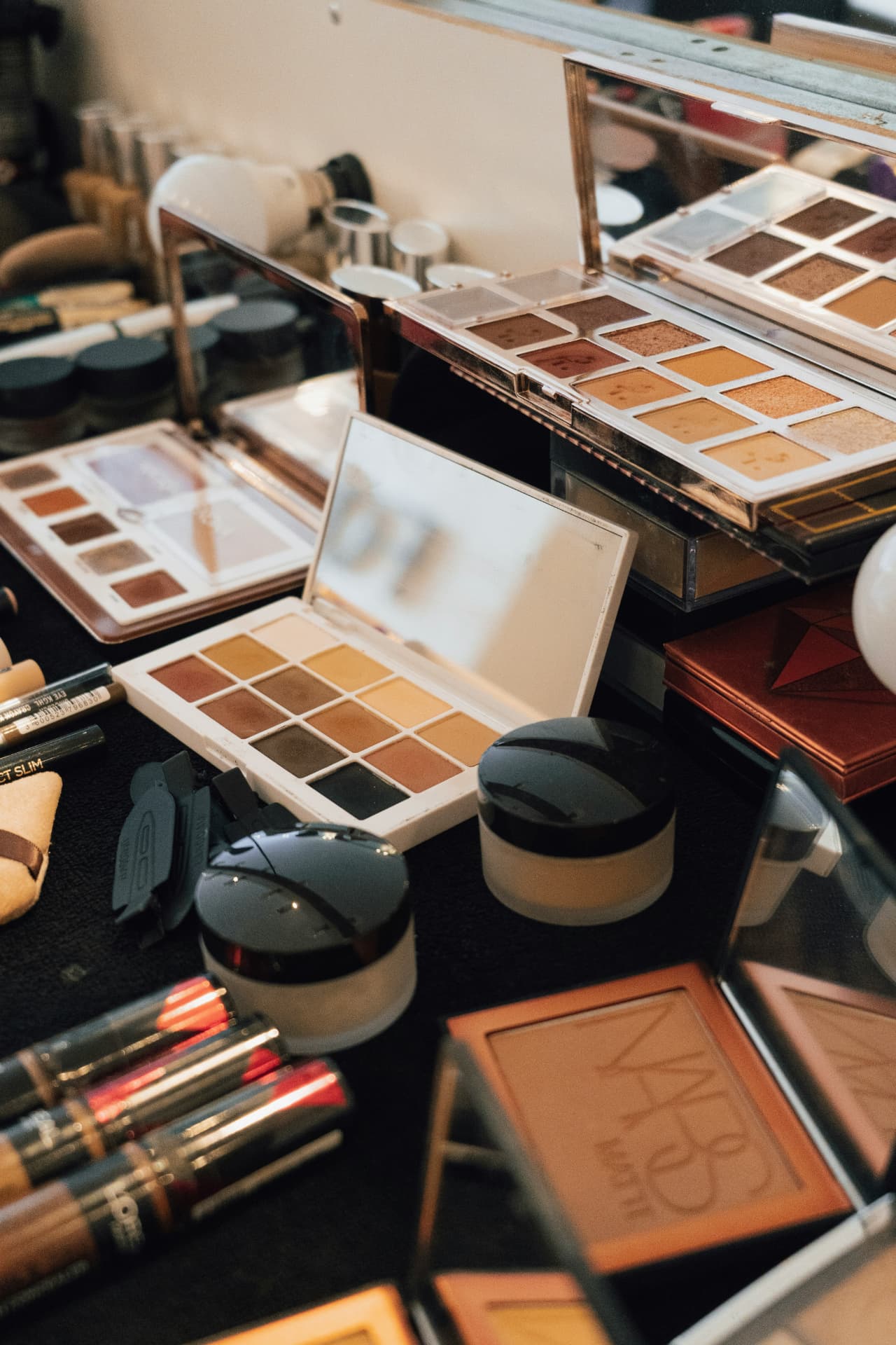 Postazione trucco con più palette di ombretti, ciprie e terre abbronzanti