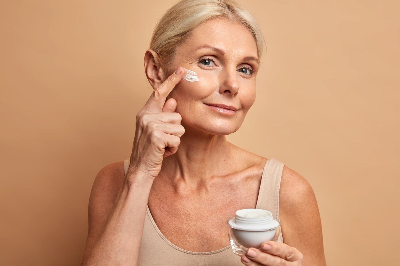 Donna matura applica crema antirughe sul viso