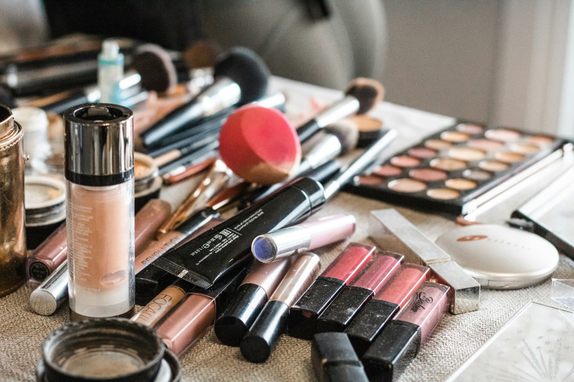 Postazione trucco con fondotinta, ciprie, pennelli e prodotti make-up disposti sul tavolo
