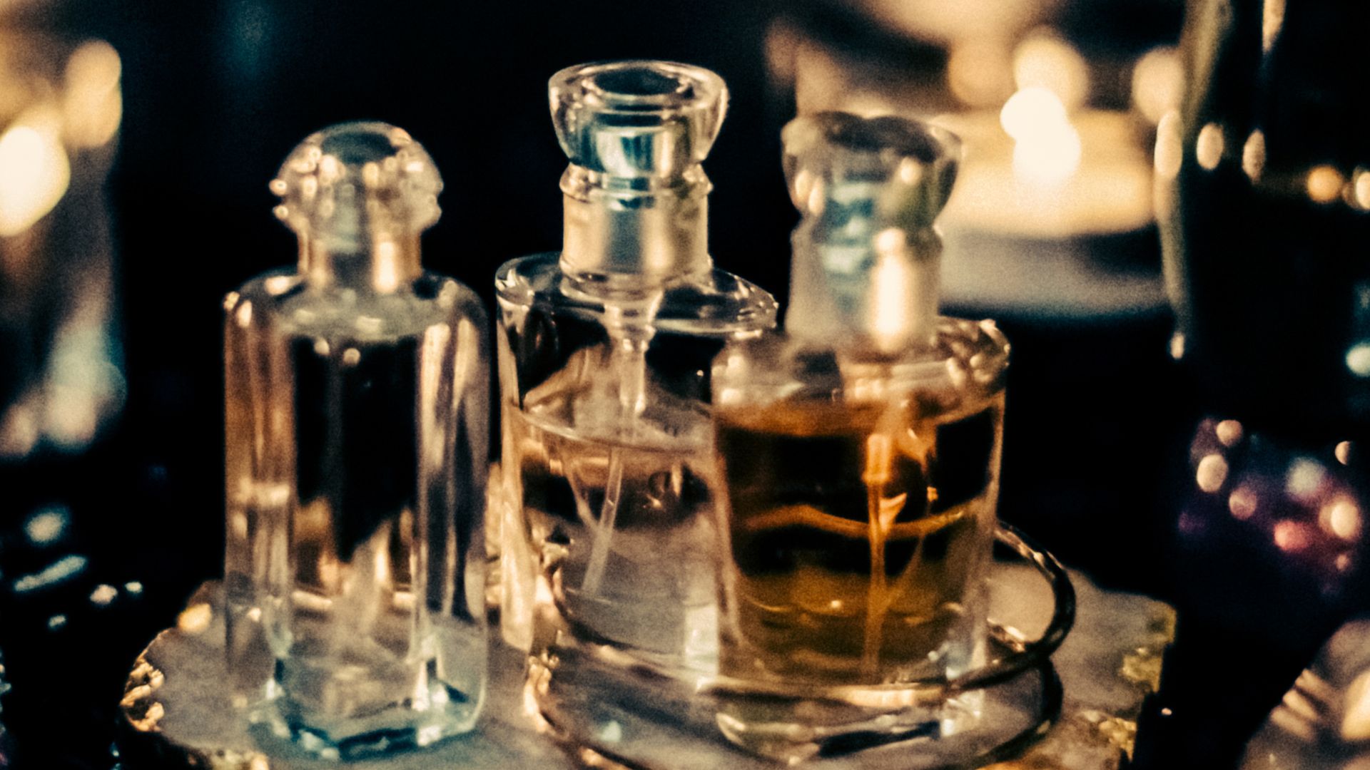 Flaconi di profumo in vetro con luci soffuse