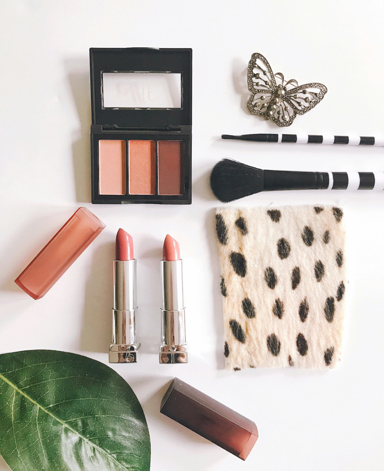 Palette viso in tonalità pesca con due rossetti nude e pennello da blush