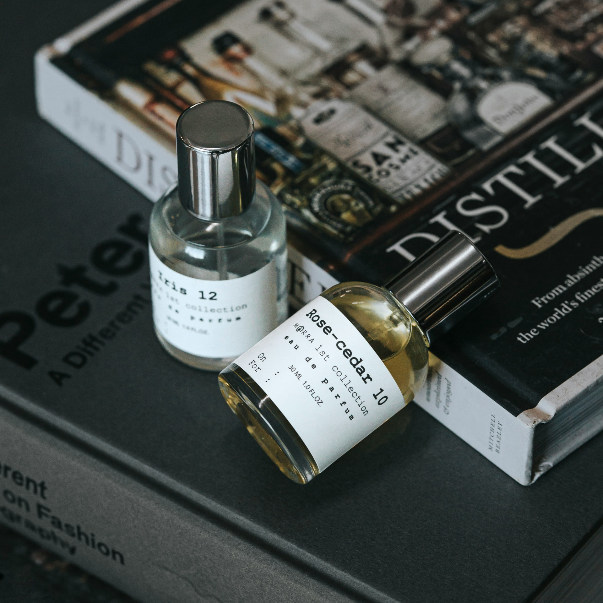 Due flaconi di profumo di nicchia in eau de parfum appoggiati su libri di profumeria artistica