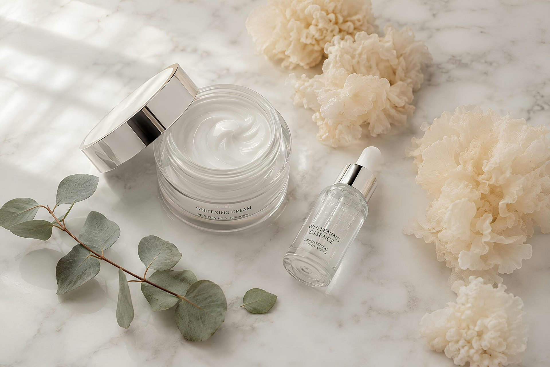 Crema viso illuminante e siero in flacone su marmo chiaro con fiori bianchi ed eucalipto